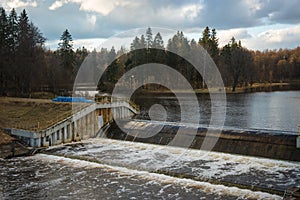 A dam on a small river and a pond with wooded island near Moscow