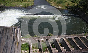 Dam wall and overflow of Iskar Dam. Water flowing over a dam wall. Mist rising above the Iskar dam wall. Cascade from a hydroelect