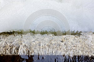 Dam at winter flowing water and ice