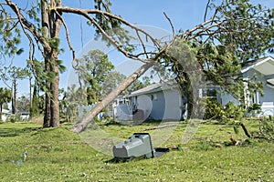 Damage to Florida house roof from uprooted tree after hurricane. Insurance claim on destroyed home. Aftermath of natural