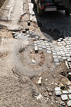 Damaged asphalt pavement with potholes. Bad road