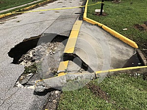 Deep sinkhole on an asphalt roadway. Damaged asphalt road collapse and fallen. Photo image