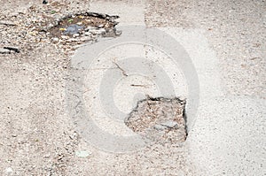 Damaged asphalt road pothole with deep holes selective focus