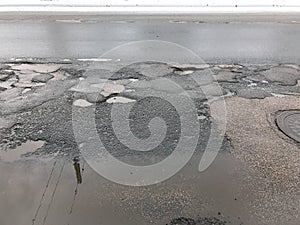 Damaged asphalt road with potholes