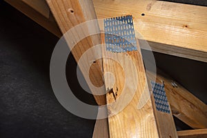 Damaged barbed plate connecting the roof structure covered with a membrane on a single-family house, damaged truss visible.