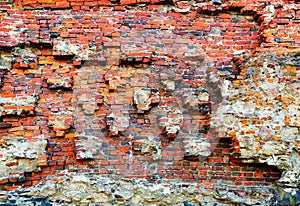 Damaged brick wall of red color. Vintage background, old weathered texture. Shabby surface of grunge masonry. Vintage facade.