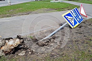 Damaged Broken Traffic Signs With Bus Direction Arrow and Pedestrian Crossing Road are Laying on the ground on a Street