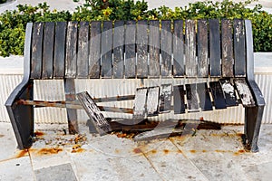 Damaged and broken wooden brown bench, aging or vandalism concept