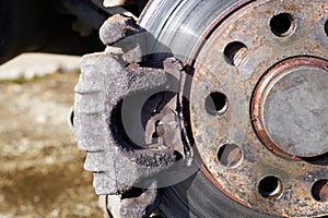 Damaged car brake pad and rusty spoiled rotor