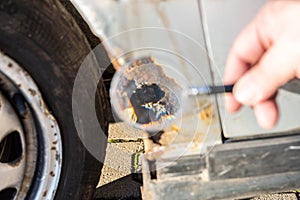 Damaged car examined using a loupe