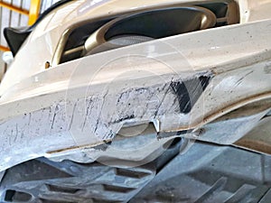 Damaged car front bumper from road scraping