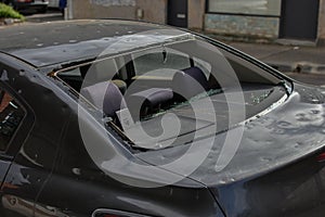 Damaged car with smashed rear window waiting repair at an auto panel garage.
