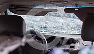 Damaged car window after an accident. Broken windshield as a result of an accident, inside view. Cabin interior details, view from