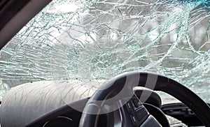 Damaged car window after an accident. Broken windshield as a result of an accident, inside view. Cabin interior details, view from