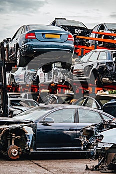 Damaged cars waiting in a scrapyard to be recycled or used for s