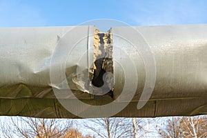 Damaged Central heating pipe. Break in the insulation of the heating main