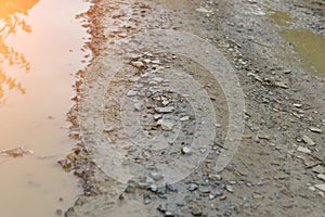 Damaged concrete road is a hole and water.