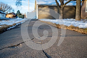 Frost heave crack in residential concrete sidewalk photo