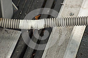 Damaged corrugated hose repaired with adhesive tape