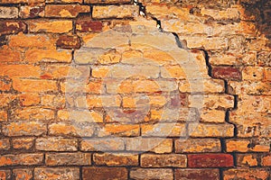 Damaged cracked old brick wall structure, due to structural foundation failure and deterioration of building materials