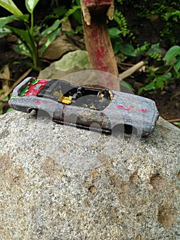 Damaged diecast found among stones and plants