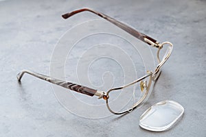 Damaged eyeglasses on table in optical shop waiting for repairing