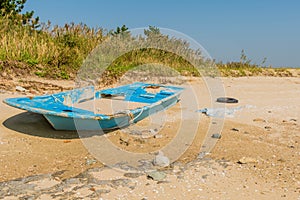 Damaged flat bottom boat filled with sand