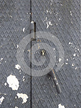 Damaged gray metal sheet with lock, latch and hinge. Grunge Metal texture background. Architecture and construction pattern.