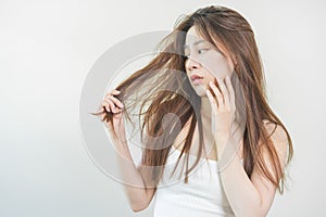 Damaged Hair, frustrated asian young woman, girl hand in holding splitting ends, messy unbrushed dry hair with face shock, long