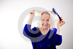 Damaged Hair. Sad adult Woman With Disheveled Comb Closeup Portrait Of Female Model Holding Unbrushed Dry Hair In Hands