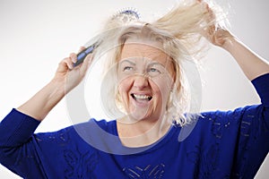 Damaged Hair. Sad adult Woman With Disheveled Comb Closeup Portrait Of Female Model Holding Unbrushed Dry Hair In Hands