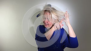 Damaged hair. Sad adult woman with disheveled comb closeup portrait of female model holding unbrushed dry hair in hands