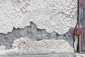 A damaged house wall and flaked exterior plaster with a large hole, Germany