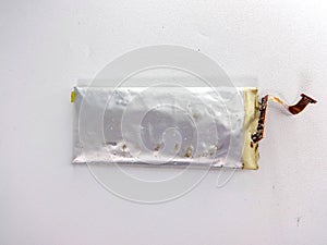 A damaged lithium polymer (LiPo) battery is shown on a white surface