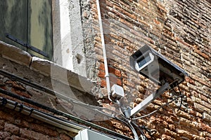 Damaged Old Surveillance Camera on Brick Wall