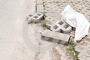 Damaged parking lot space tiles and bricks pavement