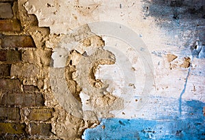 Damaged plaster on the brick wall