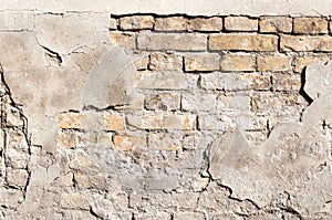 Damaged plaster on the old brick wall facade.