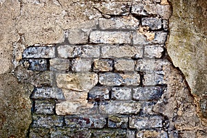 Damaged rendered brick wall
