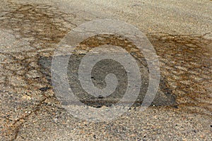 Damaged road, cracked asphalt. Asphalt with potholes and spot. Very bad asphalt road with large cracks. Scary technology in road