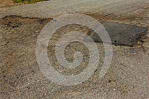 Damaged road, cracked asphalt. Asphalt with potholes and spot. Very bad asphalt road with large cracks. Scary technology in road