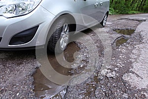 Damaged road full of cracked potholes