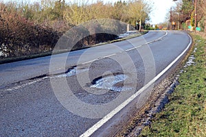 Damaged road with pot holes in it.