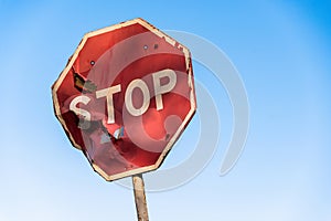 Damaged road sign stop covered with scratches