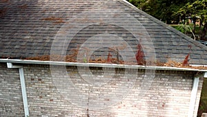 Damaged roof, shingles and gutters on home.