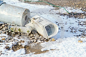 Damaged surveillance camera on the ground as a concept of failing policy of total surveillance. Vandalism act during riots.