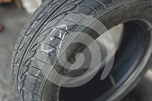 A damaged tire with a lodged screw marked with a white pen. Fixing and vulcanizing a flat tire