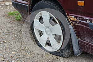 Damaged tire. The wheel of car tire leak. Flat tire on the off-road waiting for repair