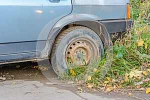 Damaged tire. The wheel of car tire leak. Flat tire waiting for repair. Abandoned car in the parking lot