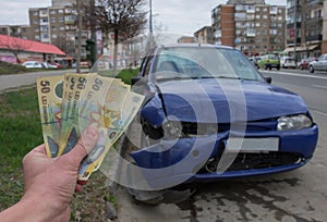 Damaged vehicle after car accident parked on the roadside. Car insurance concept with Romanian money lei Ã¢â¬â the cost of car